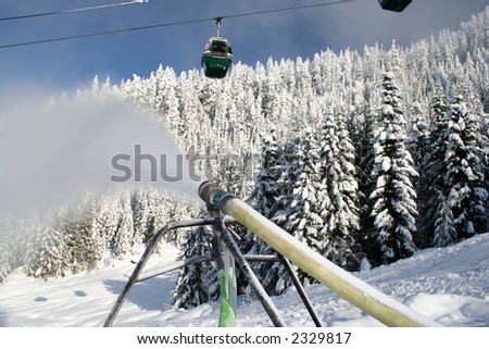 A snowmaking gun blows artificial snow onto the slopes of a ski hill.