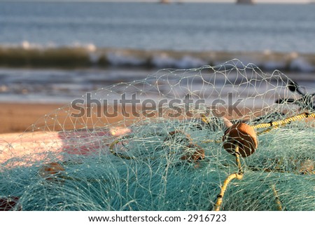 A fishing net with the Pacific ocean in the background.