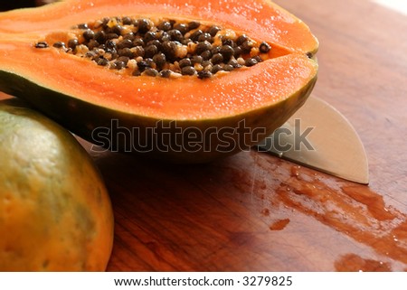 The orange flesh and black seeds of a freshly cut papaya.
