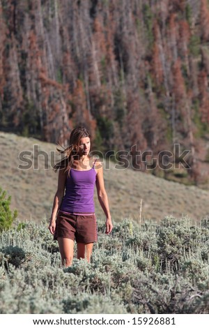 A naturally beautiful girl walking through a meadow of sage near Rocky Mountain National Park, Colorado.