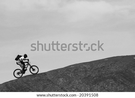 A lone mountain biker rides a steep section of Moad's famous slickrock mountain bike trail.