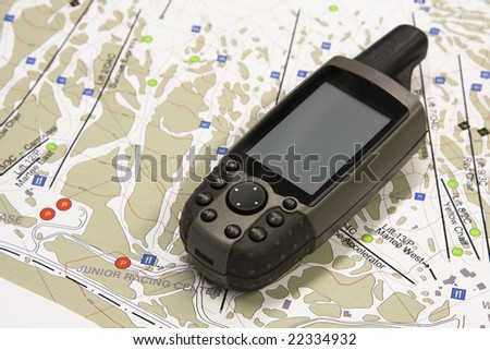 A handheld global positioning unit sits on a topo map.  The screen is blank and ready for your text.