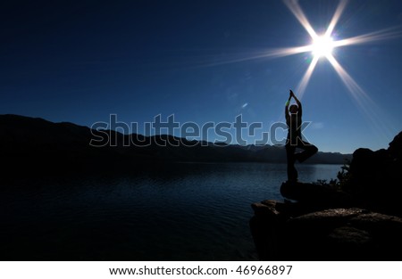 A woman in the Tree posture beside a lake in southern Argentina.