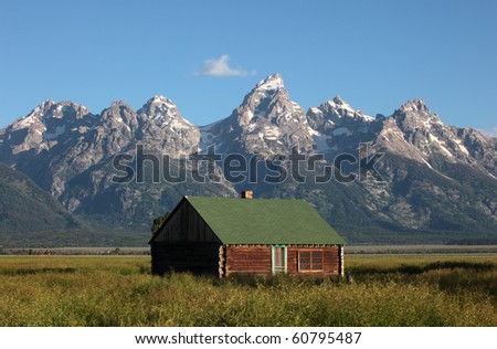 A weathered home sits against the backdrop of the Grand Tetons in Wyoming