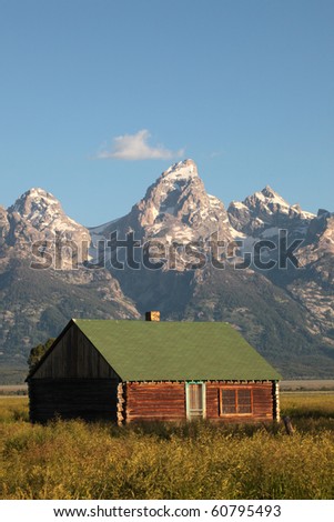 A weathered home sits against the backdrop of the Grand Tetons in Wyoming