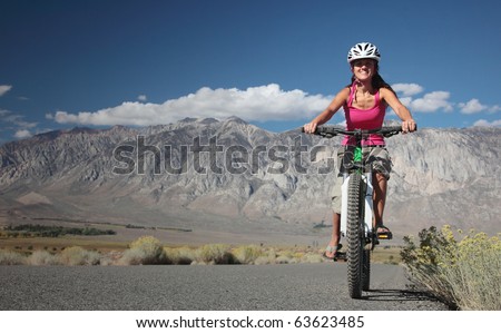 A strong woman rides along the road in the Sierra Nevavda of California.