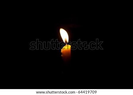Yellow candle in dark background