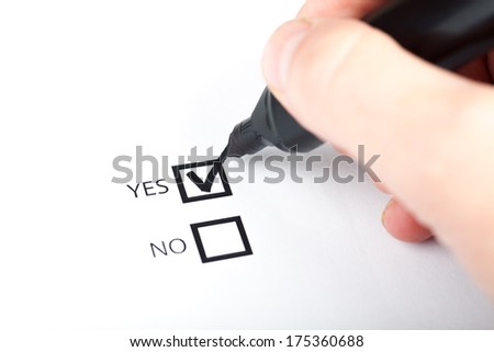 Hand with pen marking a check box