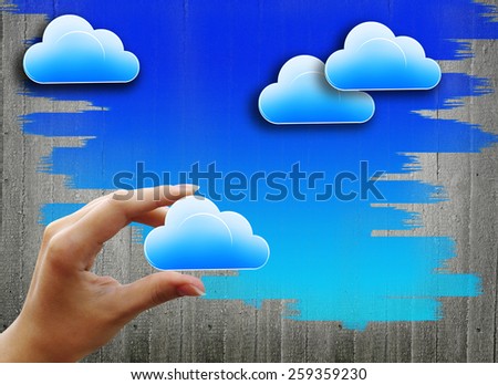 The hand with the cloud in the background of a concrete wall with painted sky