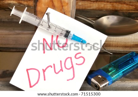 Disposable medical syringe, nailed to a board. Drug abuse concept