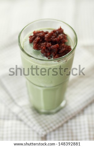 glass of green tea smoothies decorate with red beans