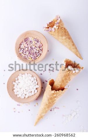 empty ice cream cones with colorful sprinkles on white background