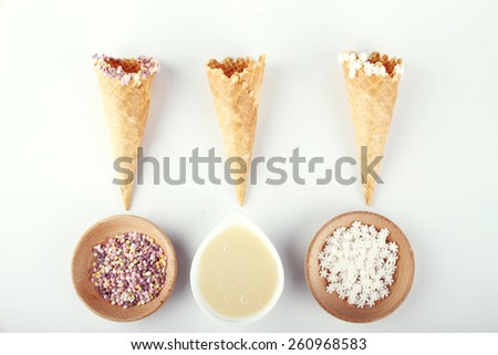 empty ice cream cones with colorful sprinkles on white background