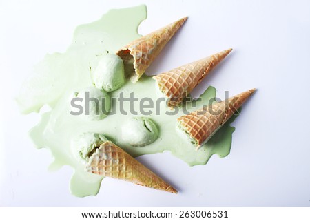 green tea ice cream cones dropped upside down on white background