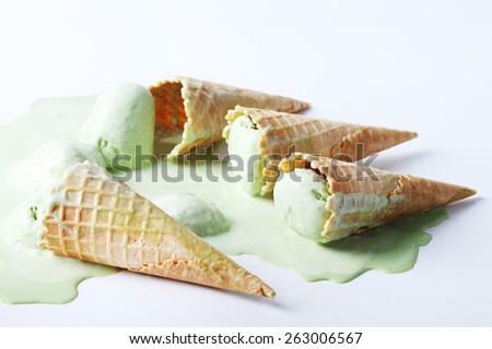 green tea ice cream cones dropped on white background