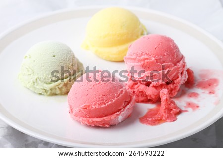 ice cream scoops on white round plate on white background