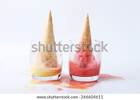 yellow passion fruit and red strawberry ice cream cones dropped melt on ground