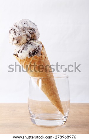homemade cookie and cream ice cream scoop in clear glass on wooden background