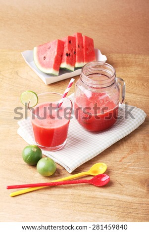 Healthy watermelon lime smoothie and fresh watermelon on a wooden background