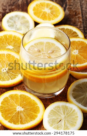 drink and stack of citrus fruits slices. Oranges and lemons. On wooden plate