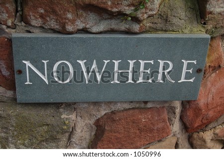 Nameplate for house called nowhere connected to a sandstone and brick wall