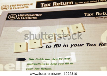 Taxes spelt out using keyboard letters on a UK tax return form background