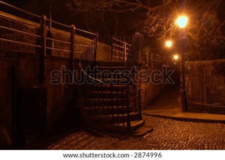 Steps onto the Roman Wall in Chester at night lit up by streetlights.