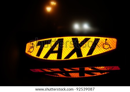 Taxi sign lit up showing the word Taxi and the disabled symbol