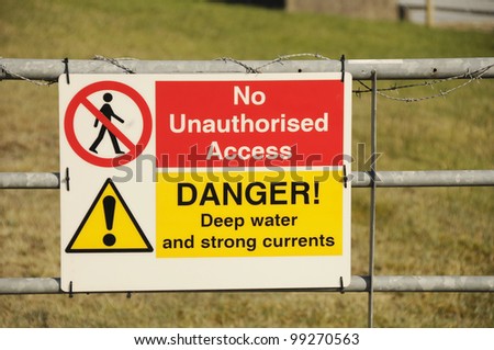 Warning sign on a gate saying no unauthorised access and advising of deep water and strong currents.