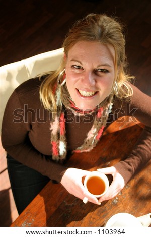 Woman drinking tea while the sun shines through the window Woman drinking tea while the sun shines through the window
