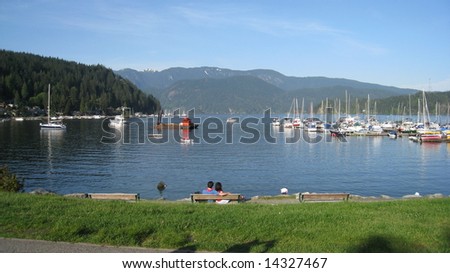 a couple sitting in deep cove watching the boats , a romantic moment
