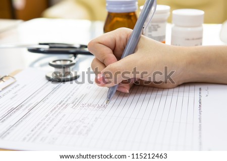 Doctor hand writing a medical recipe
