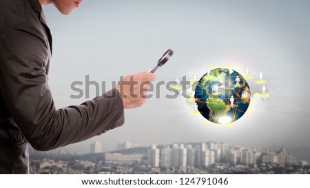 Business man look small world under a magnifying glass   (Elements of this image furnished by NASA)