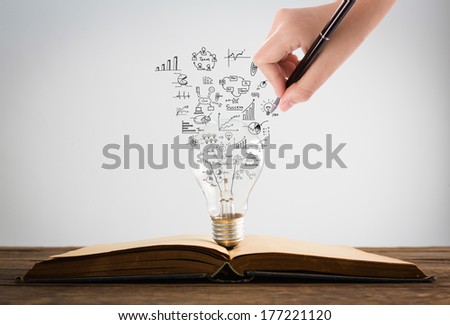 Book and light bulb with hand drawing graph