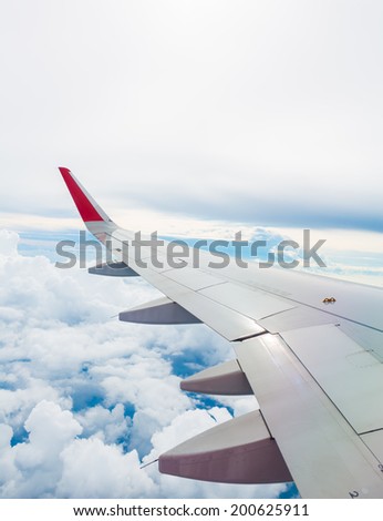 Wing of an airplane flying above the clouds