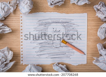 Pencil erase and hand drawn light bulb on paper with Crumpled paper