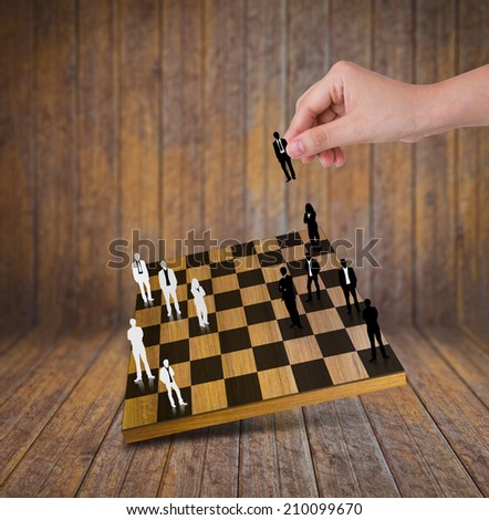 Hand Playing chess game with Silhouettes of business people
