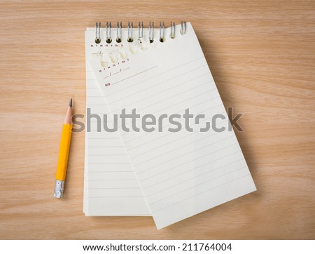Note book with pencil on a wooden desk