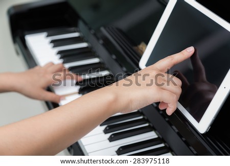 Woman hand use tablet and  playing piano music