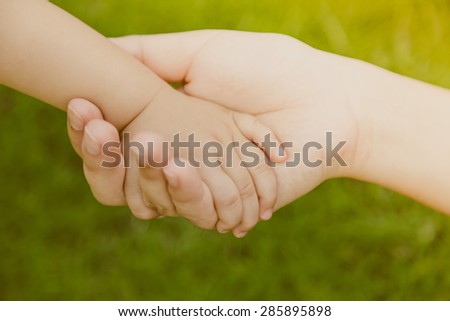 Mother holding baby hand ( Filtered image processed vintage effect. )