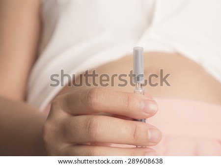 Pregnant woman with syringe in hand ( Filtered image processed vintage effect. )