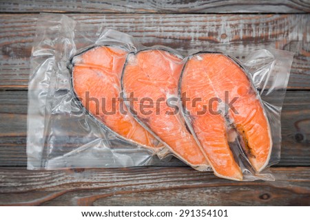 Frozen salmon fillets in a vacuum package wood table