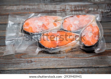 Frozen salmon fillets in a vacuum package wood table