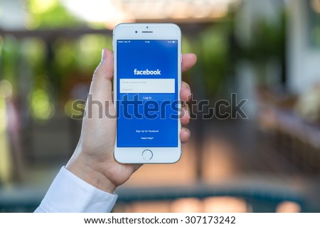 Loei, Thailand - August 12, 2015: Hand holding Iphone with mobile application for Facebook on the screen