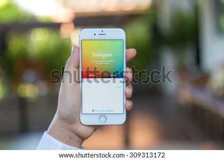 Loei, Thailand - August 12, 2015: Hand holding iPhone with mobile application for Instagram on the screen