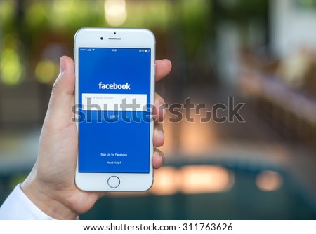 Loei, Thailand - August 12, 2015: Hand holding Iphone with mobile application for Facebook on the screen
