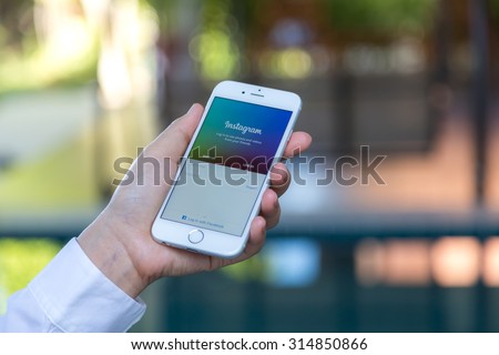 Loei, Thailand - August 12, 2015: Hand holding Iphone with mobile application for Instagram on the screen