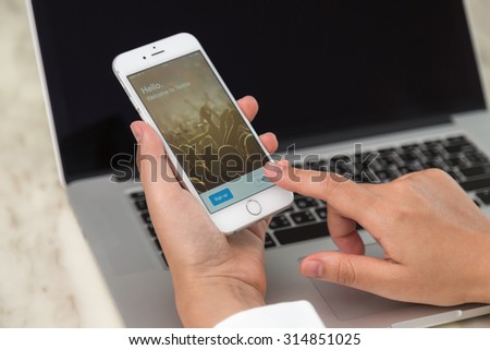Loei, Thailand - August 12, 2015: Hand holding Iphone with mobile application for twitter on the screen