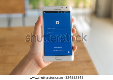 Loei, Thailand - August 7, 2015: Hand holding samsung galaxy note edge with mobile application for Facebook on the screen