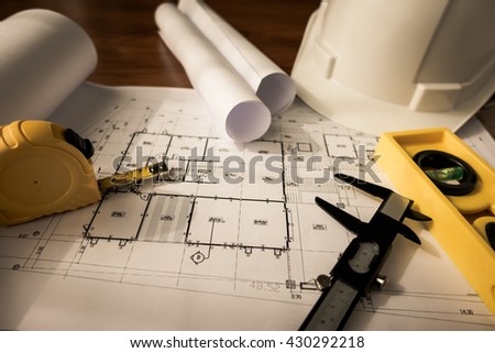 Construction plans with White helmet and drawing tools on blueprints  ( Filtered image processed vintage effect. )